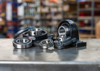 Industrial bearings and pillow block housings, shown on a metal workbench at PT Hose & Bearing.
