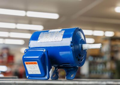 Electric motor used in industrial applications for power generation, shown on a metal workbench at PT Hose & Bearing.
