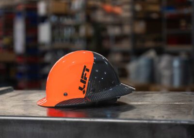 Industrial hard hat helmet for workplace safety, shown on a metal workbench at PT Hose & Bearing.