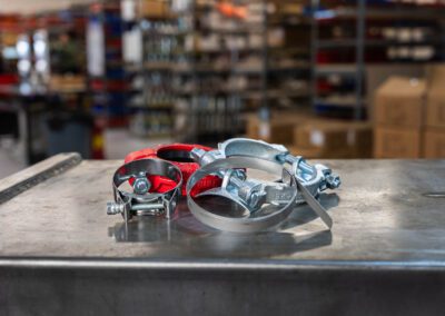 Industrial hose clamps for securing hoses in industrial applications, shown on a metal workbench at PT Hose & Bearing.