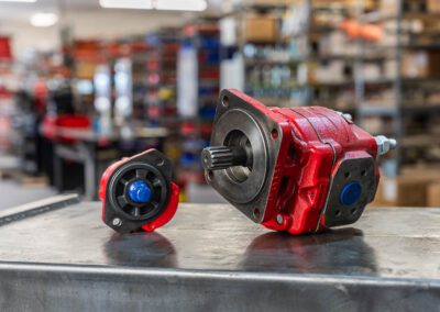 Hydraulic motor and hydraulic pump for industrial fluid power systems, shown on a metal workbench at PT Hose & Bearing.
