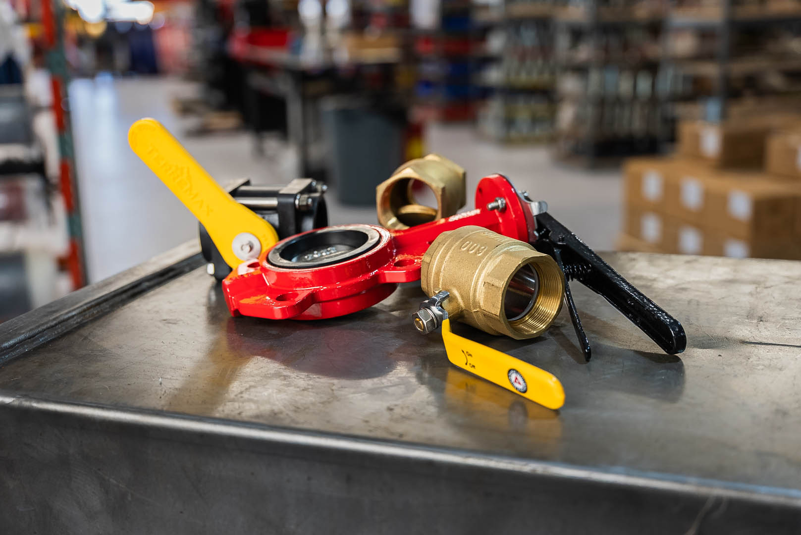 Valves Industrial valves, including butterfly and ball valves, with yellow and black handles on a metal workbench at PT Hose & Bearing